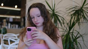 Dial secret message. girl uses the phone several times and looks around sharply to do something secret. A young woman is afraid of being noticed