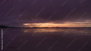 Uyuni Salt Flats at Sunset. Salar de Uyuni. Aerial View. Altiplano, Bolivia. Rainy Season. Reflection on Water in Lake Surface. Drone Flies Forward at Low Level