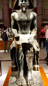 The statue of King Khafre in the Egyptian Museum is one of the most iconic masterpieces of ancient Egyptian art. King Khafre, known for commissioning the Great Sphinx and the second pyramid at Giza, is depicted seated majestically on a throne. The statue is made of diorite, a hard and durable stone that symbolizes the king's strength and divine nature. The craftsmanship showcases intricate details, such as the king's muscular form, his serene and confident facial expression, and the Horus falcon
