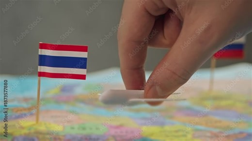 Toy airplane between Thailand and Russia flags over colorful world map, symbol new long haul routes, tourism charters, cultural exchange and growing Thai carriers presence in Russia air travel.
