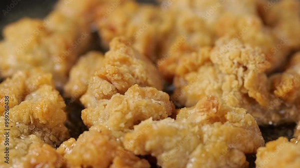 Deep-fried chicken nuggets in the pan, emphasizing the richness of flavor and the art of frying for perfect crispiness.