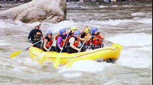 Experienced white water rafting pilot expertly guides and instructs a young group,ensuring an exhilarating adventure.