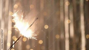 burning sparkler with a double flame back and forth. closeup. lighting of festive sparklers, blurred shiny light background. the concept of a festive party. new year's sparkler.
