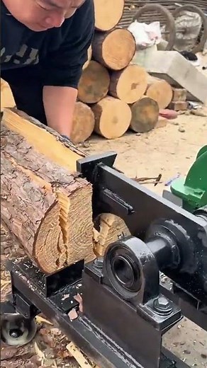 splitting wood logs using a mechanical log splitter for professional forestry fuel production work