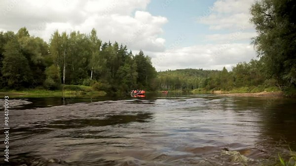 Large Rubber Rafts with People Floating on a Wide River Through the Forest. Rafting is Recreational Outdoor Activity which use an Inflatable Raft to Navigate a River or Other Body of Water.