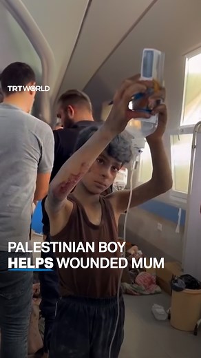 A Palestinian boy helped his mother as she received treatment on a hospital floor after she was injured by an Israeli air strike in Palestine's Gaza. | TRT World