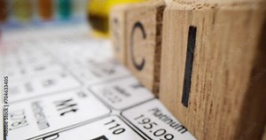 Flasks with samples of petroleum products and periodic table of chemical elements in laboratory