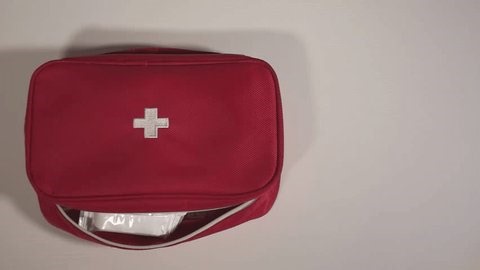 clip-3997700475-first-aid-kit-woman-table-white-high