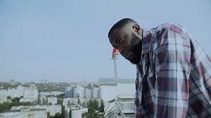Desperate afro-american man standing rooftop, problem difficulties, hopelessness