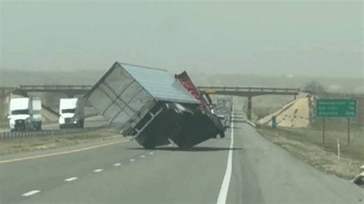 Tractor trailer teeters and topples in intense wind