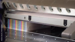 Worker cutting paper using paper cutting machine in a printing factory. Printing cutting machine, final cut