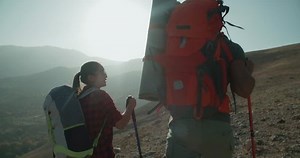 Hikers people hiking - healthy active lifestyle. Hiker people hiking in beautiful mountain nature landscape. Woman and man hikers walking during trekking hike.steady-cam shot