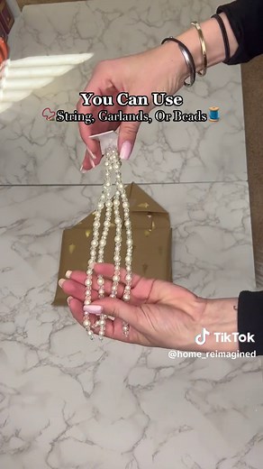 🎁Come learn how to wrap a book into this adorable gift purse!👛 Lay your book sideways on the paper and make sure you have enough to cover the book before cutting it! 🪚 For a real looking purse, fold the long side of the paper into itself for a clean seam, then fold onto the book & secure with tape. 🔐 Ensure you leave a small amount the bottom for folding and more paper at the top for later! ⏰ Then push in the sides at the bottom to make a triangle, and secure it back to the center.🔻 Smooth 