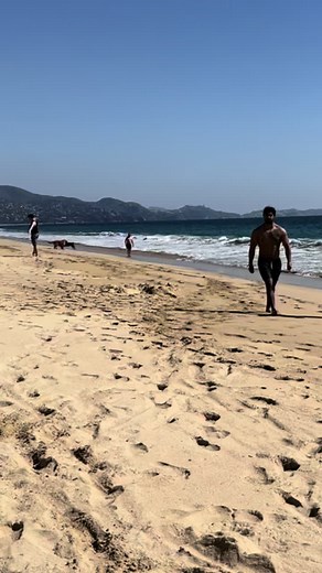 Shirtless Man Strolling on Scenic Beach