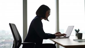 Download Typing on Laptop at Desk in Office High Rise Building Window Background for free