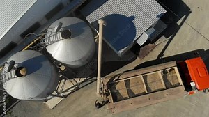 Car reloader with a trailer filled with grain, for transportation to the warehouse. Grain handling in silos using specialized equipment. Automatic feeding system