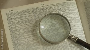 Magnifying glass on large opened book Stock Video