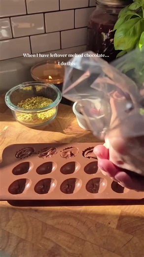 5 minute homemade Easter candy... I had leftover melted chocolate after making granola bars, and instead of letting it harden in the bowl, I scooped it into a piping bag and filled a silicone candy mold. Instant homemade chocolate candy. These little chocolate Easter eggs are going straight into the freezer to save for Easter baskets. Before they set, I sprinkled the backs with chopped pistachios and crushed freeze dried strawberries for a little color, flavor and texture. Simple. Fun. And made 