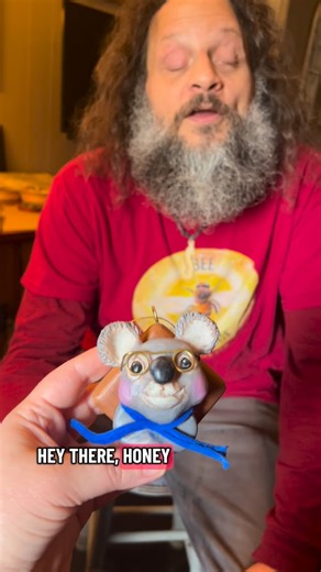 John Furniss on Instagram: "My newest little creations! #trashPanda #raccoon #koala #giraffe #sculpting #polymerClay #art #clayArt Description: Anni shows John, who is blind, her Clay ornaments. The animal busts are attached to wood bases that John has made. The first one is a koala with rosy cheeks wearing good rimmed glasses and a blue scarf, the second one is a raccoon wearing a navy blue beanie hat and a navy blue and white striped scarf. The third one is a giraffe with holiday lights wrappe
