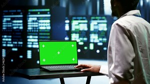 Electrician auditing server clusters doing intense computations. Serviceman using chroma key laptop to check strain on data center components caused by AI applications driving up power usage