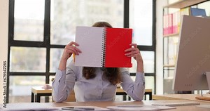 Woman puts down notepad and closes face at workplace