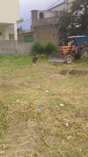 Operating an Orange Tractor in a Rural Setting