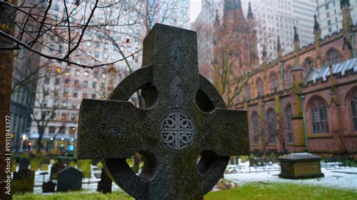 New York, USA, 25 December 2025: Celtic cross monument in Trinity Church cemetery. Close up of a stone Celtic cross with intricate carvings in a snow covered graveyard.