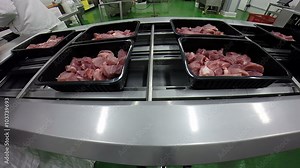 Meat Processing and Packing Factory / Plastic boxes with fresh meat on a conveyor belt in meat processing facility.HD1080p