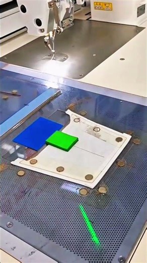 Fabric aligned under sewing machine needle with laser guide