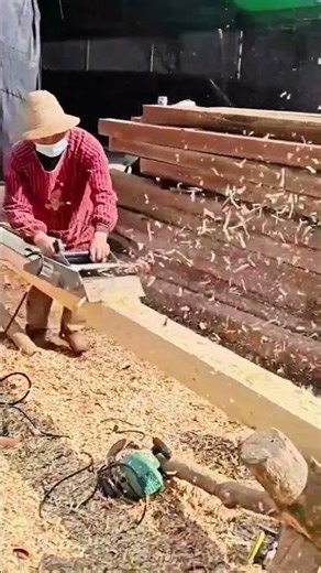 cutting trimming smoothing wooden beam using electric planer while working outdoors under warm