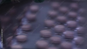 Automated packing at drug production. Closeup slow motion shot of an automated pill packaging machine.Tablets in Packages on a Conveyor. Pharmaceutical machinery for medicine production Pills.