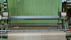 weaving looms. weaving factory. textile industry. Close-up. Automated weaving machine is fabricating cloth of threads. Textile factory equipment. fabric production.