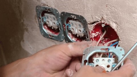 clip-4000024615-installer-hands-mounting-outlet-module-into-plaster