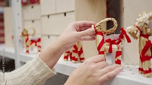 Traditional Swedish Christmas goat julbock made of straw in female hands.