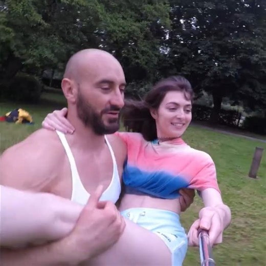 Bodybuilder runs across London park carrying woman