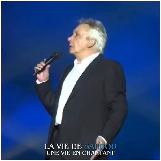 Michel Sardou interrompu par sa mère en plein concert (sketch) 😂 Lors de ses concerts, Michel Sardou rend souvent hommage à ses parents, Fernand et Jackie Sardou, figures marquantes du spectacle. Un moment culte reste le sketch "Maman" de 1982, où sa mère Jackie l'interrompt sur scène pendant qu'il tente de chanter Comme d'habitude. Ce duo plein d'humour montre Jackie, fidèle à son tempérament truculent, taquiner son fils avec des remarques comme "Souris!" ou "Pas trop de gestes!", le ramenant