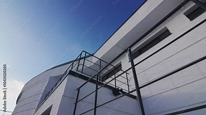Wall of building made in light colors complemented by observation platforms with dark railings. Renovated design of Spatial Planning Institute