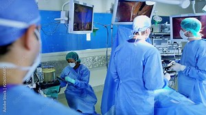 Training medical team in scrubs in the operating theater of Multi ethnic origin using an Endoscopy to specialise in Laparoscopy surgery via video camera technology