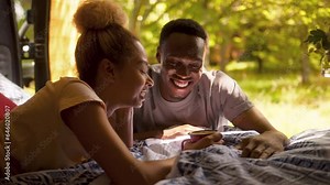 Couple Enjoying Camping In Countryside Relaxing Sitting Inside RV Together