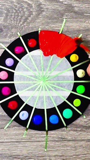 Brush lays orange stroke on circle, crisp rhythm of morning painting craft