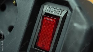 Turn off power supply by pressing red push-button switch of black extension cord with your finger. Heal. Savings concept. Idea of electrical overload and safety filter with fuse.