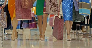 Close-up, the legs of women are walking through the store, women are holding shopping bags in their hands. Girls in the store for sale, bottom view. 4k, ProRes
