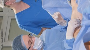 The surgeon performs an operation on the legs with varicose veins using a modern, laser ablation