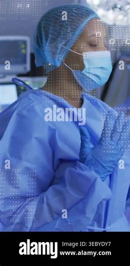 Vertical video: Surgeon turning raising gloved hand camera zoom in OR overlay on hand showing prep. Hospital, operating, room, sterile, monitors, teamwork, vertical video Stock Video Footage - Alamy