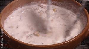 Seafood chowder boiling in a clay pan in UHD