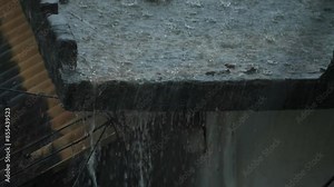 Raindrops falling from a gutter creating a dynamic splash effect