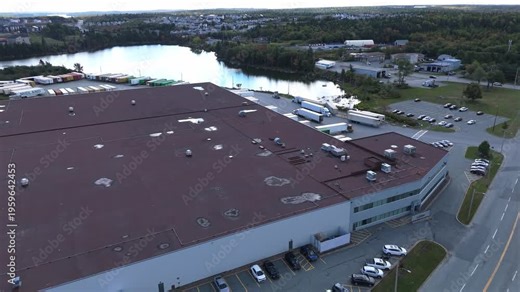Aerial drone perspective of a major logistics park in Halifax, Nova Scotia. Many semi-trucks parked at loading ramps of a large warehouse, busy freight and distribution center in Canada 4K.