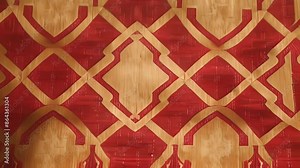 The texture of this patterned fabric wallpaper showcases a repeating geometric pattern in bold shades of red and gold adding a touch of opulence to any room.