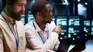 Coworkers overseeing supercomputers helping businesses manage databases, host websites and store files. Technicians auditing server room infrastructure used for high performance computing