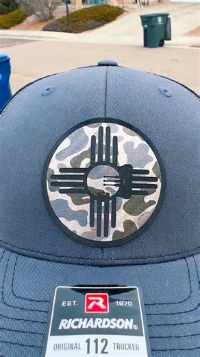Look closer. This isn’t your average Zia. 🏹✨ We took the iconic New Mexico symbol and integrated a bow sight into the center for those who live for the hunt. Finished on our custom Camo Carbon Fiber leatherette, this patch is designed to be as rugged as the terrain you scout. Built on the classic Richardson 112, it’s the perfect lid for your next scouting trip or a weekend at the range. #MartinezDesignCo #NMBowhunter #ArcheryLife #Zia #bowsight | Martinez Design Co.